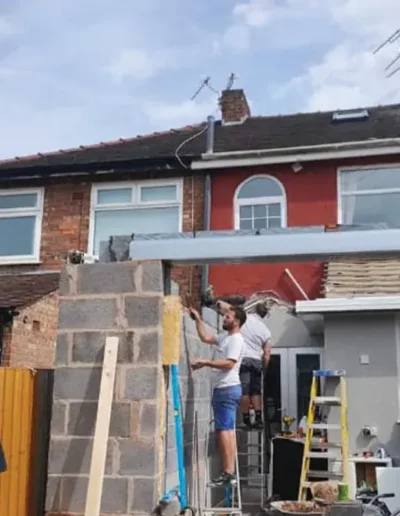 Rear extension blockwork under construction in Liverpool with builders working on ladders